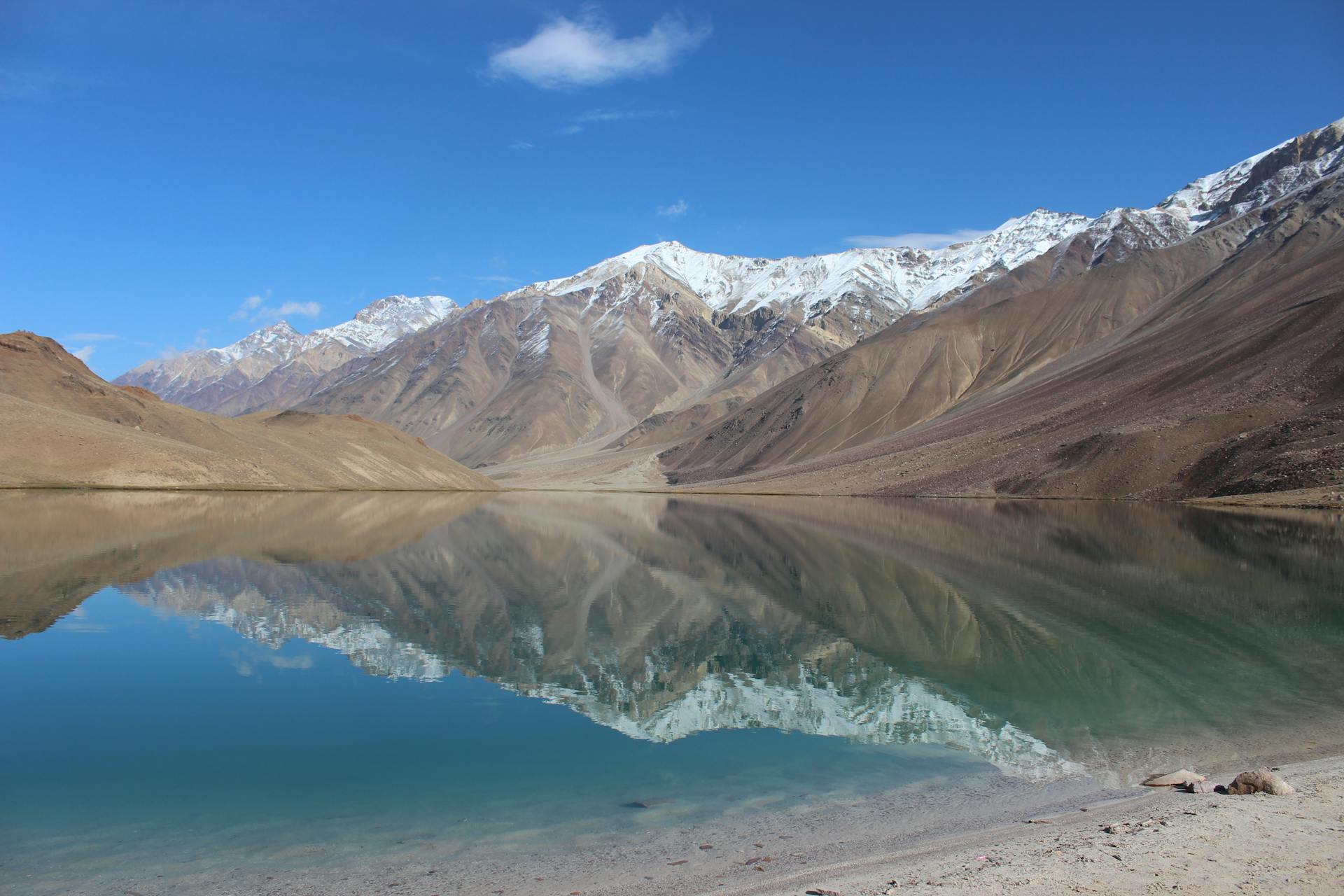 Chandratal Lake with mountains reflected in the crystal blue water